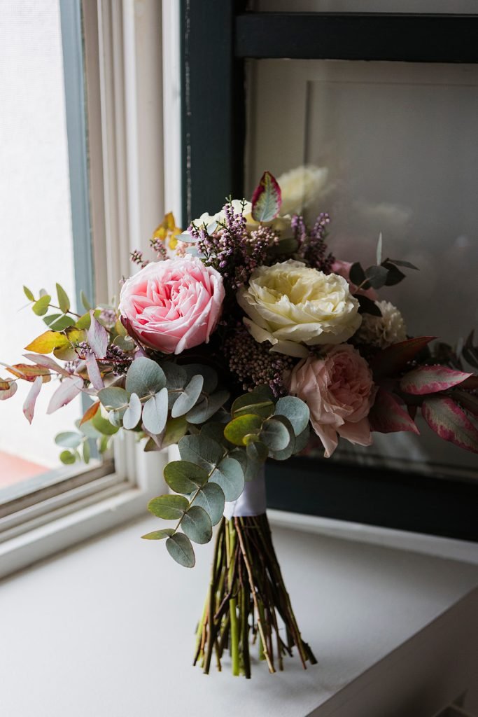 Fine art bridal details including vintage earrings, a pastel rose bouquet, and an elegant bride in a lace dress. Artistic wedding photography by Flor de Sal Photo.