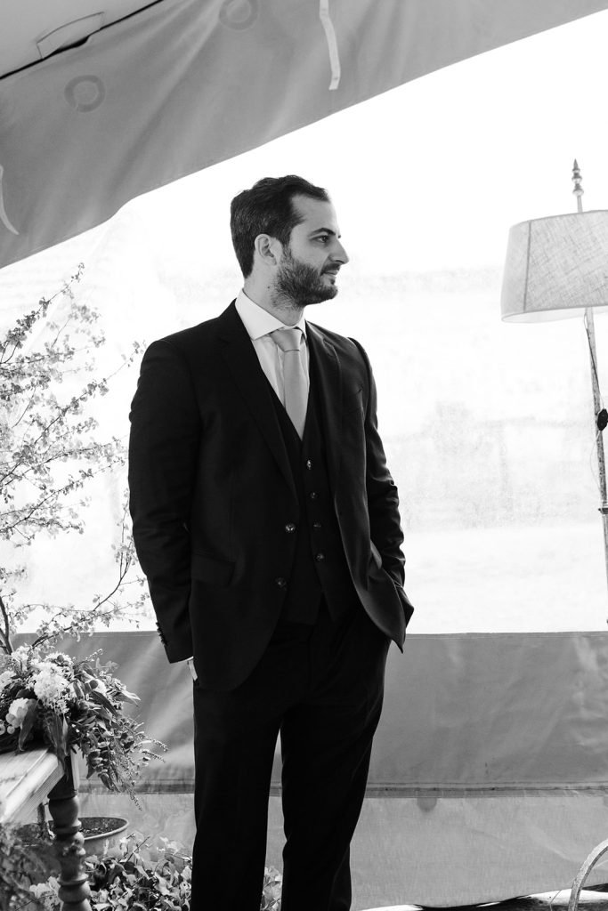 Documentary black and white wedding photography. The groom waiting and the bride walking with her father at a rustic countryside venue named Finca Aldeallana. Flor de Sal Photo.