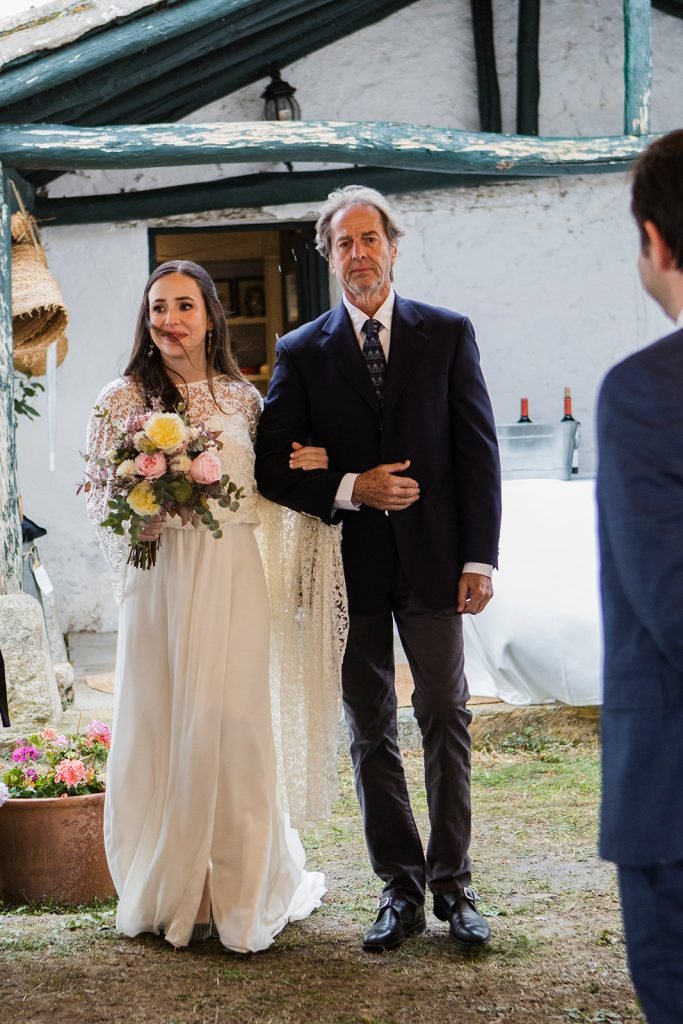 Documentary wedding photography, the bride walking with her father at a rustic countryside venue named Finca Aldeallana. Flor de Sal Photo.