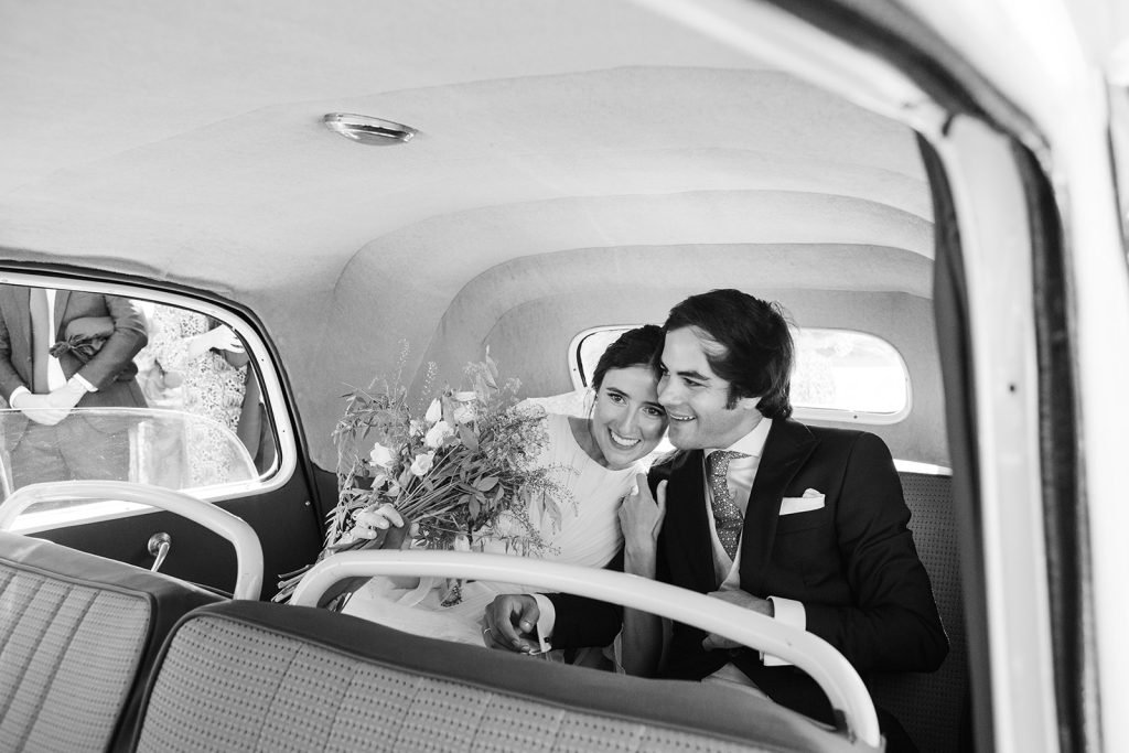 Fotoperiodismo de boda artístico en blanco y negro, capturando momentos naturales, espontáneos y elegantes de unos novios dentro de un coche en la iglesia de los jerónimos en madrid por flor de sal photo