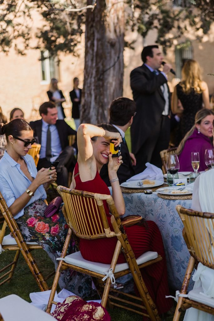Candid photograph of wedding guests laughing naturally at the reception tables. Unposed documentary wedding photographer.